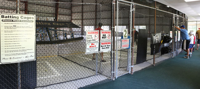 Fenced entryway to batting cages with rules posted on signs