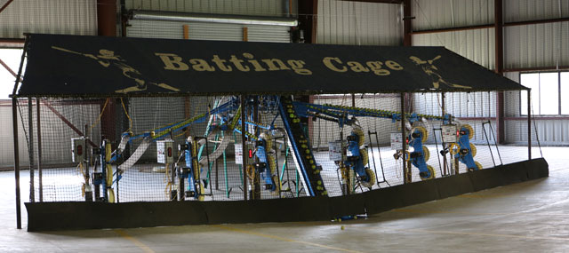 Six batting cages viewed from behind without batters