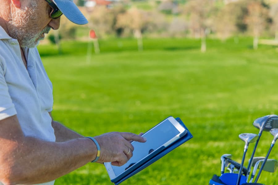 Golfer using tablet to track data on course