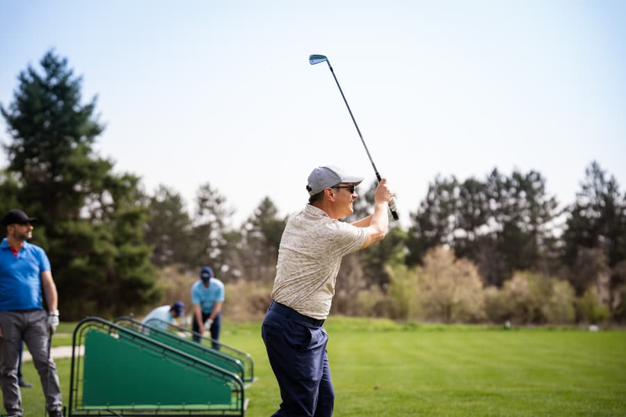 People practicing hitting golf balls on driving range
