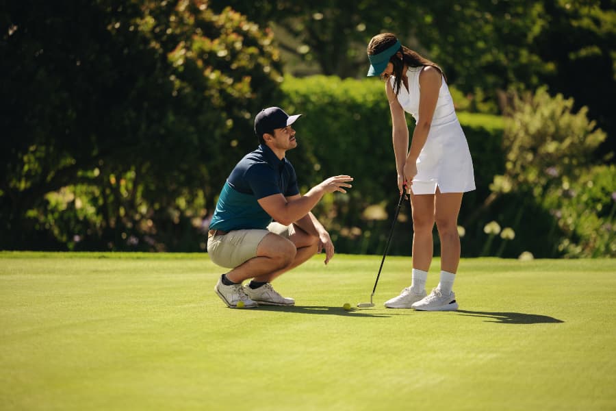 Golf instructor coaching player holding club on golf course